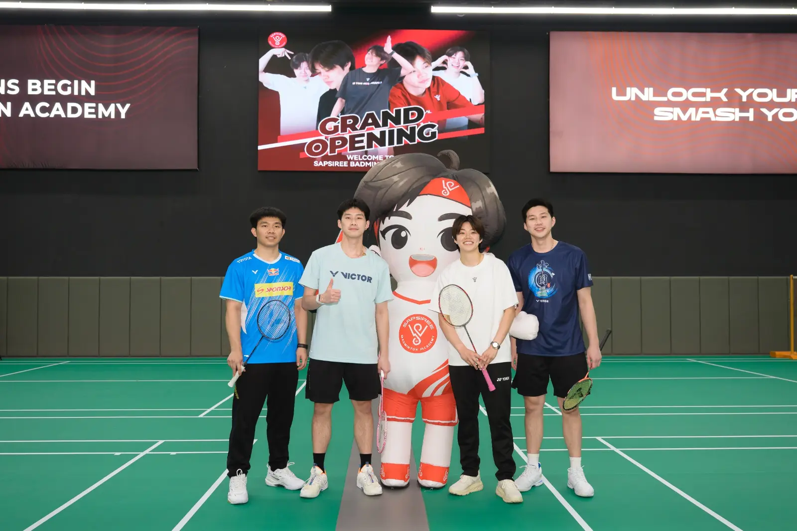 Sapsiree Taerattanachai, badminton players and the academy mascot at the grand opening